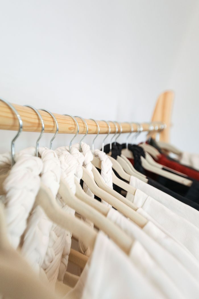 Mastering the First Impression: Your intriguing post title goes here A row of elegant garments on hangers in a minimalist wardrobe setting.